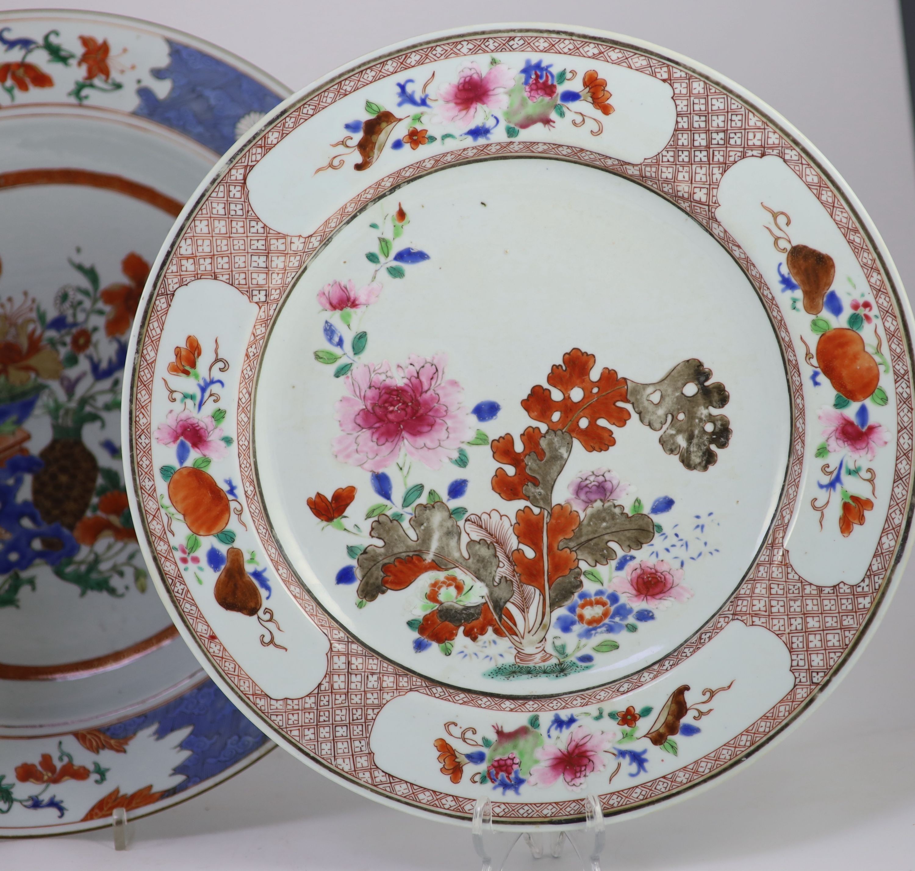 A pair of Chinese export famille rose dishes and a similar charger, early Qianlong period, diameter 35 cm and 42 cm, the charger broken and repaired